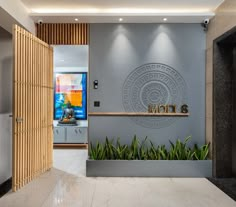 an entrance to a modern home with plants in the foreground and artwork on the wall