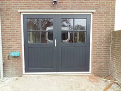 two double doors in front of a brick building with glass on the sides and side windows