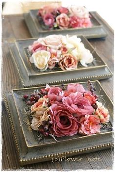 three trays with flowers on them sitting on a table