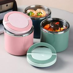 three containers with lids are sitting on a table next to a toaster and microwave