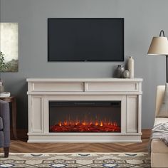 a living room with a fireplace and television on the wall in front of an entertainment center