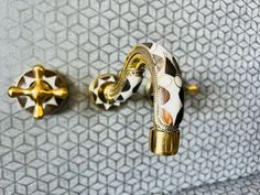 two gold and white decorative knobs on a wall