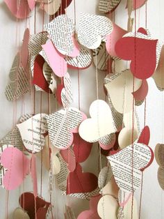 some paper hearts hanging from strings on the wall