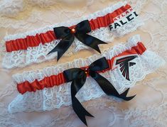 Handcrafted wedding garter set.  Created w/ red satin & white lace.  Centered w/ black satin bow & red rhinestone.  To the side sits a Falcons applique made from lightweight cotton fabric. Garters stretch comfortably up to and at 22". Please note that this product is in no way an official, licensed NFL product.  I am in no way affiliated with the NFL.  This is a handcrafted product, using licensed NFL material only. Personalization is available for an additional fee. Please leave the names and date in the box provided. If you would like a personalized ribbon for BOTH garters, please choose the personalized option in the drop down menu for your main garter, then add this to your purchase for the second garter... https://www.etsy.com/listing/545841738/additional-personalized-ribbon-for Large Atlanta Falcons Football, Falcons Football, Satin Noir, Wedding Garter Set, Wedding Garters, Personalized Ribbon, Bridal Garter, Wedding Garter, Garter Set