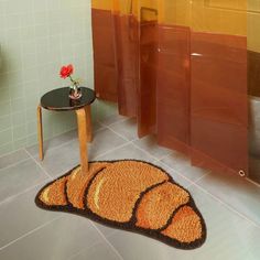 a bath room with a toilet and a rug on the floor next to a table