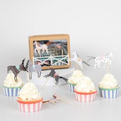 several cupcakes with horses on them sitting in front of a photo frame