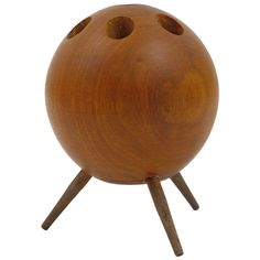 a wooden object with three holes in the middle and two legs on each side, sitting on a white surface