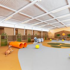 an indoor play area with toys and animals on the floor, including large orange tubes