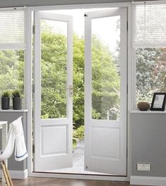 an open white door with blinds on the windowsill and wooden flooring in front of it