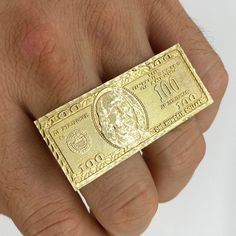 The Hundred Dollar Bill Money Ring Two Finger Ring is the ultimate symbol of wealth and power. Designed with intricate details, this bold ring spans across two fingers, capturing the essence of luxury and financial success.  Material: Copper, Sterling Silver. Color: Gold. Size: 5.0, 5.5, 6.0, 6.5, 7.0, 7.5, 8.0, 8.5, 9.0, 9.5, 10. Style: Small/28.7mm, Medium/41.2mm, Large/48.6mm. Process: 14K Gold plated. Ring Type: Two Finger Ring. Recipient: Women, Mom, Wife, Girl Friend, Children, Family. Bra Gold Two Finger Ring, 2 Finger Ring Gold, 3 Finger Ring, Gold Rings Two Fingers, 2 Finger Ring, Money Ring, Bill Design, Money Rings, Two Finger Ring