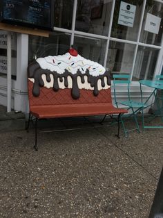 an ice cream sundae sitting on top of a red bench