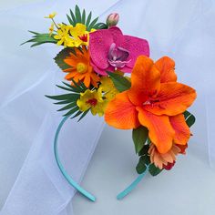 an orange and pink flower arrangement on a headband