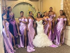 a group of women standing next to each other wearing purple dresses and posing for the camera