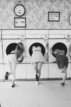 two women are in front of the washers and looking at each other's butts