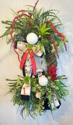 a christmas wreath with golf balls and greenery