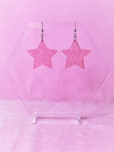 Pink Sparkle Star EarringsChoice of sterling silver .925 or surgical stainless steel(These earrings pictured are made with surgical stainless steel)Approximately 1.5" wide, and 2.5" long from top of metal hookThese pink sparkle earrings are super pretty. They are made with a transparent light pink acrylic, with tiny sparkles. They shine beautifully when they move around, lightweight and are a great pop of color!This product is made to order, colors may appear slightly differentCare: the metal an Star Shaped Nickel Free Plug Earrings For Gift, Stainless Steel Star Charm Earrings Gift, Trendy Star-shaped Earrings As A Gift, Stainless Steel Star Earrings For Gifts, Star Shaped Stainless Steel Earrings For Gifts, Stainless Steel Star Charm Earrings For Gift, Trendy Star-shaped Earrings For Gifts, Nickel-free Star Shaped Plug Earrings For Gift, Star-shaped Nickel-free Plug Earrings As Gift