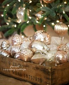 a wooden box filled with ornaments next to a christmas tree