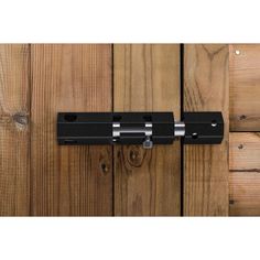 a black door handle on a wooden door with wood planks in the back ground