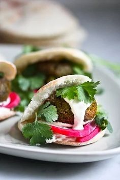 two falafel sandwiches on a white plate