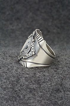 This finely crafted sterling silver ring was made by Navajo silversmith Derrick Gordon. The back is signed Derrick and stamped sterling.Size: 11Length: 1"Free shipping on all orders! We ship with USPS and always include tracking. All orders ship within a day of payment.Returns are accepted up to 30 days after you receive your order. Just send us a message. Our shop offers cash back or store credit. The item must be returned in new condition. Sterling Silver Turquoise Ring With Concho, Southwestern Engraved Round Rings, Southwestern Style Engraved Round Rings, Silver Turquoise Concho Ring In Sterling Silver, Silver Southwestern Style Rings, Silver Bohemian Concho Rings, Bohemian Silver Concho Rings, Southwestern Style Untreated Silver Rings, Southwestern Silver Rings Collectible