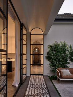 an outdoor living area with tiled flooring and glass doors