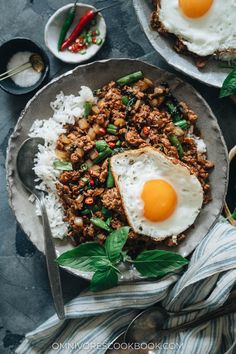 an egg is on top of rice with green beans and other foods in the background