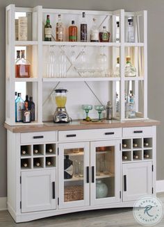 a white cabinet filled with bottles and glasses