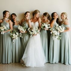 a group of women standing next to each other holding bouquets