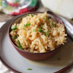 a bowl filled with rice on top of a white plate