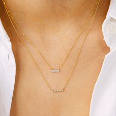 One of our most coveted items, this gold and diamond bar necklace is a DRD favorite. This dainty diamond bar necklace is the perfect piece of minimal jewelry for everyday wear. Made of 14k gold and pavé-set diamonds, this bar necklace looks amazing alone or layered. It pairs well with everything in your jewelry box. Wear it with anything from an understated tee to a little black dress. Seen on celebrities every day and on the red carpet, this piece makes a great gift for a loved one or for yourself. This gold bar necklace comes in 14k white, yellow, and rose gold and features a delicate diamond-cut mini-chain with a spring-ring clasp. The diamond bar is always 14k white gold, so the yellow and rose gold options are two-tone. 14 Karat Gold 0.04 Diamond Carat Weight Bar is 9mm in Width Avail Rose Bar, Weight Bar, Bar Necklaces, Dana Rebecca Designs, Rose Diamond, Diamond Bar Necklace, Buddha Pendant, Gold Bar Necklace, Bridal Engagement Rings