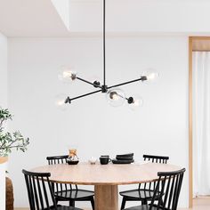 a dining room table with black chairs around it