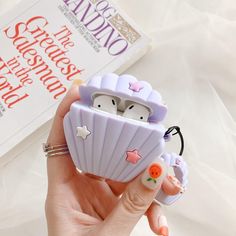 a hand holding a small purple case with two little birds in it's shell