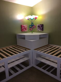 two white bunk beds in a room with green walls and lights on the wall above them