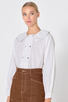 This buttoned blouse is crafted from soft, breathable cotton in a classic white. It features a double row of buttons down the front and a stylish Peter Pan collar. The long sleeves have gathered cuffs, adding a touch of elegance to the design. Perfect for both casual and formal occasions. Use our virtual size assistant to find your perfect fit. Back Button Blouse, Pan Collar Blouse, Peter Pan Collar Blouse, Big Sister Shirt, Button Blouse, Sister Shirts, Tiny Cottons, Collar Blouse, Pan Collar