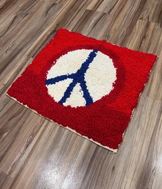 a peace sign rug sitting on top of a wooden floor