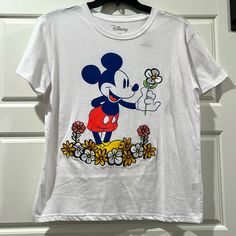 New, Never Worn Disney Tee Sporting Iconic Mickey Mouse With Flowers. He’s Holding A Daisy Embroidered Flower. Disney T-shirt For Fan Events In Spring, Spring Mickey Mouse Crew Neck T-shirt, White Mickey Mouse T-shirt, Casual Mickey Mouse T-shirt For Spring, Spring Disney T-shirt For Fan Events, Trendy White Mickey Mouse Tops, Spring Mickey Mouse Short Sleeve Top, Spring Cotton Mickey Mouse Top, Spring Mickey Mouse Cotton Top