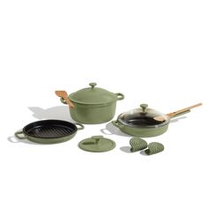 an assortment of green pots and pans with wooden utensils on white background