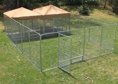 a large metal cage in the middle of some grass