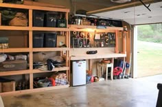 a garage filled with lots of items and storage space next to an open door that leads out onto a grassy field