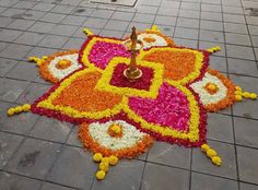 a colorful flower arrangement on the ground in front of a building with a light pole