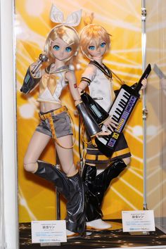 two dolls are posed next to each other with musical instruments in front of yellow background