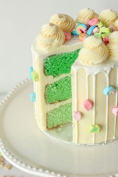 a white cake with green frosting and colorful sprinkles on the top