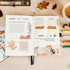 an open planner book sitting on top of a table next to pencils and markers