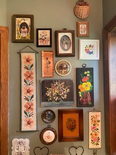 there are many framed pictures on the wall in this room, including flowers and other things