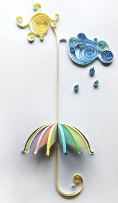 an umbrella made out of paper and some other things on top of the wall next to it