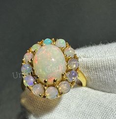 "OPAL HALO   𝐑𝐢𝐧𝐠 925 sterling silver  𝐑𝐢𝐧𝐠 𝐅𝐨𝐫  Women 𝙀𝙓𝙋𝙀𝙉𝙎𝙄𝙑𝙀 & 𝙇𝙀𝙂𝙀𝙉𝘿 𝙍𝙄𝙉𝙂   ˜\"*o*.˜\"*o* WITH  LEGENDARY  OPAL *o*\"˜.*o*\"˜ Material  925 Sterling Silver  . Gemstone OPAL Gemstone  Shape OVAL . Cut Type  Excellent . Birthstone  OCTOBER . Ring Type  Statement  . Style  Art Deco . Ring For  WOMEN" Gold Opal Multi-stone Ring, Opal Halo Jewelry As Gift, Gold Opal Rings As Gift, Gold Opal Rings For Gifts, Gold Round Opal Ring As Gift, Gold Opal Ring For Gift, Opal Rings With Halo Setting As A Gift, Opal Jewelry With Halo Setting For Gift, Opal Halo Rings As Gifts