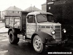 an old truck parked in front of a brick building