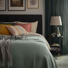 a bedroom with green curtains and pictures on the wall