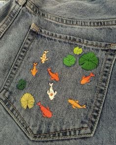 the back pocket of a pair of jeans with embroidered animals and leaves on them,