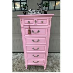 a pink chest of drawers with zebras on top